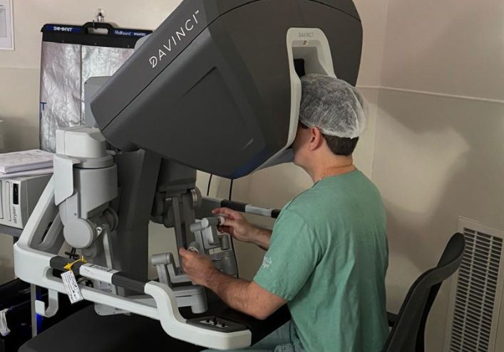 Equipe cirúrgica operando com sistema robótico minimamente invasivo
